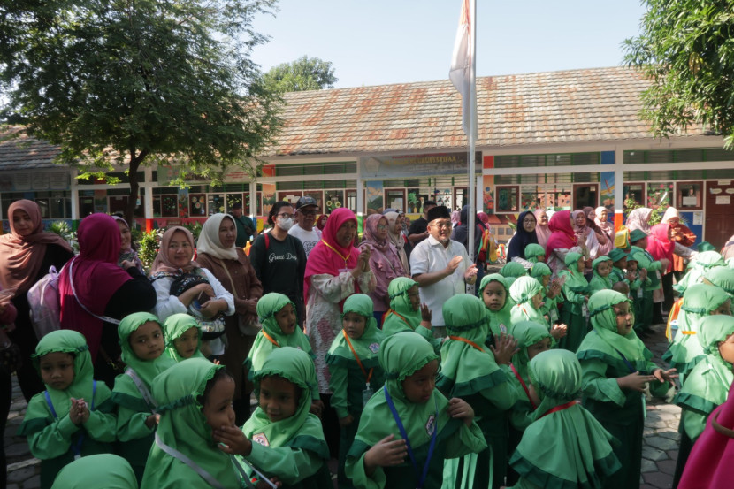 Sejumlah guru dan kepala sekolah TK Nuurusysyifa' menyambut kehadiran siswa.