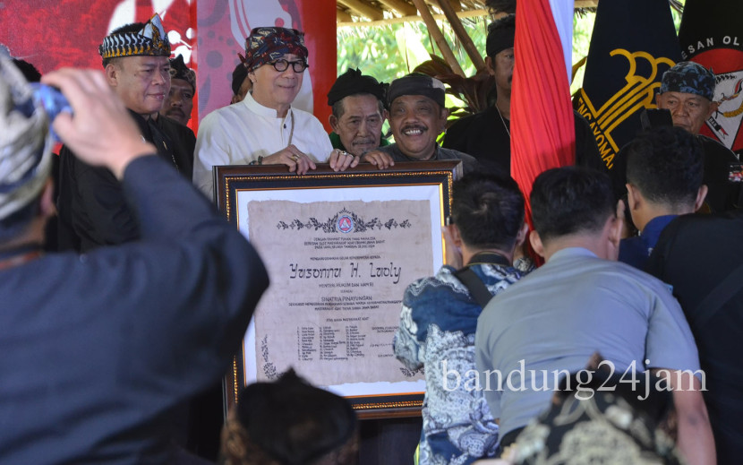 Menkumham Yasonna H Laoly menerima gelar Sinatria Pinayungan oleh Baresan Olot Masyarakat Adat (BOMA), saat acara Festival Seni Budaya Jabar, di Kawasan Ekowisata Alam Santosa, Kabupaten Bandung, Selasa (24/07/2024). Foto: Edi Yusuf