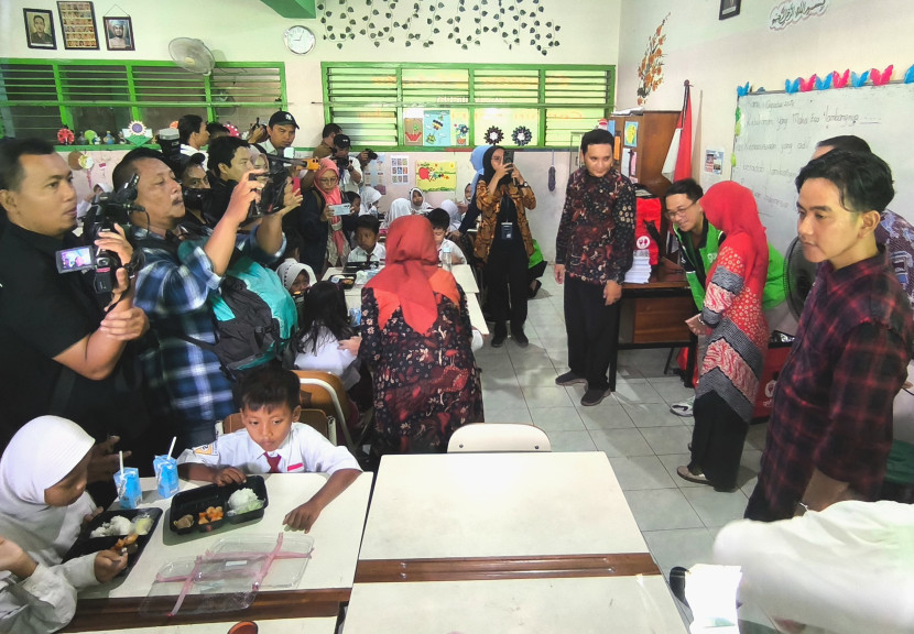 Wakil Presiden terpilih Gibran Rakabuming Raka (kemeja kotak-kotak) meninjau uji coba program makan bergizi gratis di SDN Klampis Ngasem III, Surabaya, Jawa Timur, Kamis (1/8/2024)