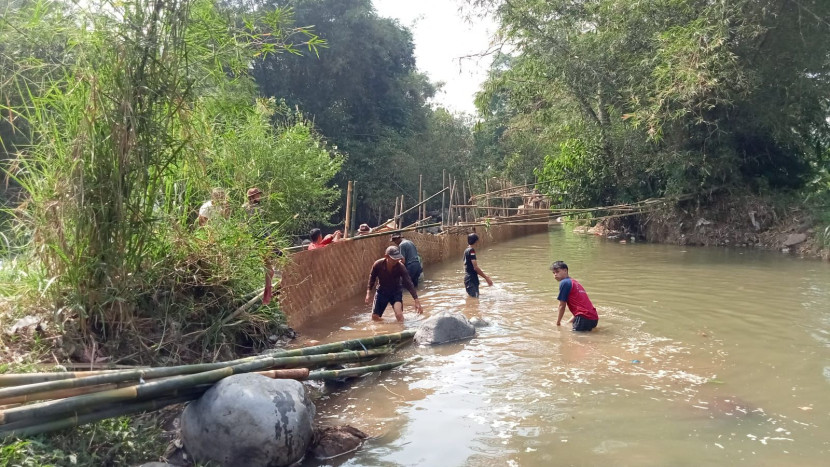 Warga saat gotong royong memperbaiki bendungan irigasi Leuwi Lio untuk di Desa Cikujang, Kecamatan Gunungguruh, Kabupaten Sukabumi, Ahad (11/8/2024).