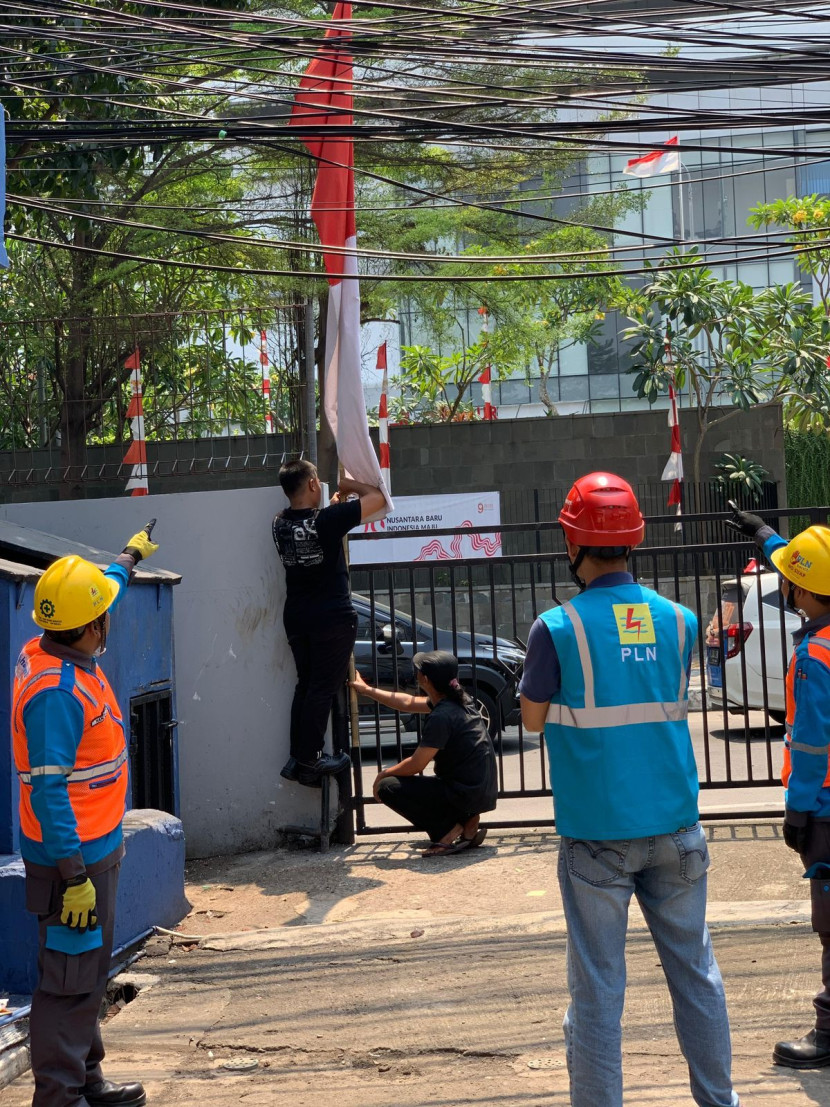 Petugas PLN mengimbau kepada masyarakat yang sedang memasang umbul-umbul dekat dengan jaringan listrik. Pemasangan bendera atau umbul-umbul yang tidak tepat dapat mengganggu operasional jaringan listrik. (Dok PLN)