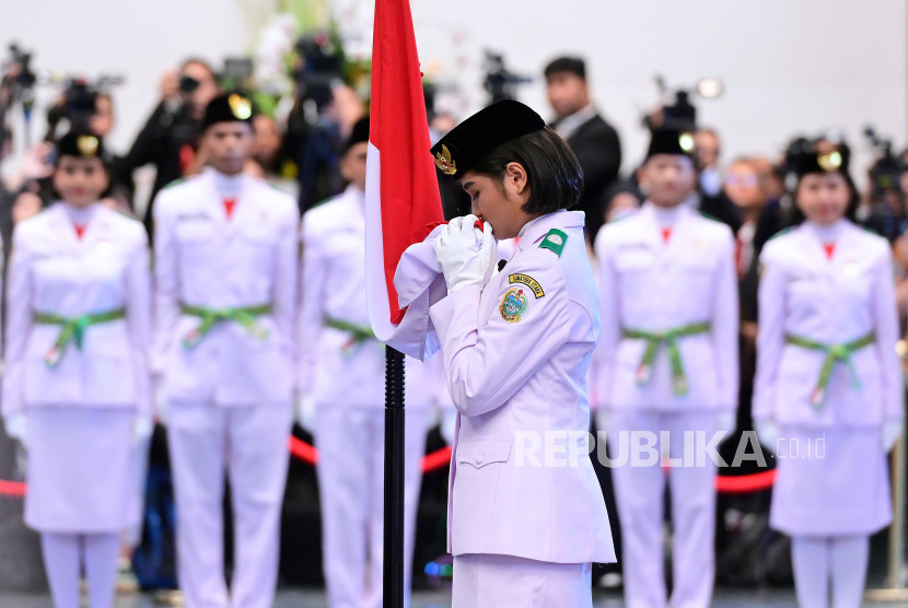 Anggota Paskibraka 2024 asal Sumatera Utara, Violetha Agryka Sianturi mencium Sang Saka Merah Putih. 