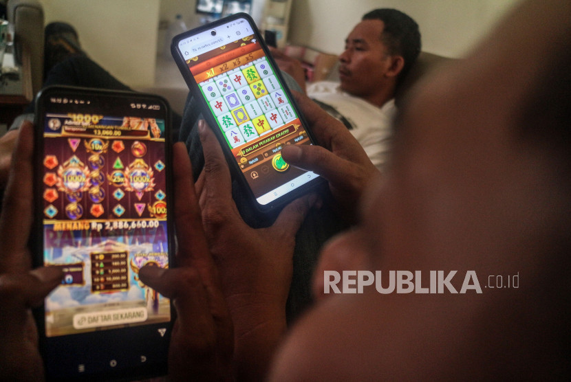 Warga bermain judi online menggunakan perangkat ponsel. (FOTO: Republika) 