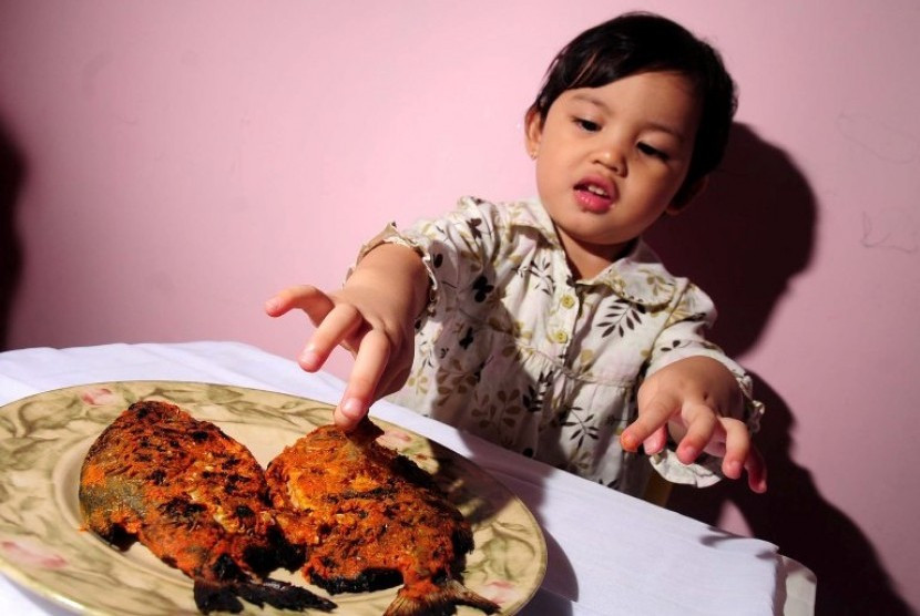 Anak makan ikan. Sumber:Dok Republika