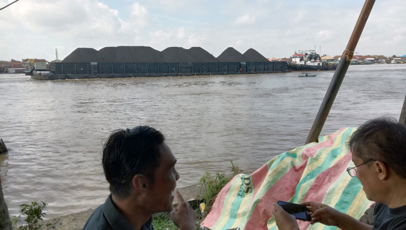 Tongkang batu bara tengah melintas di Sungai Musi. (FOTO: Aina Rumiyati Aziz)