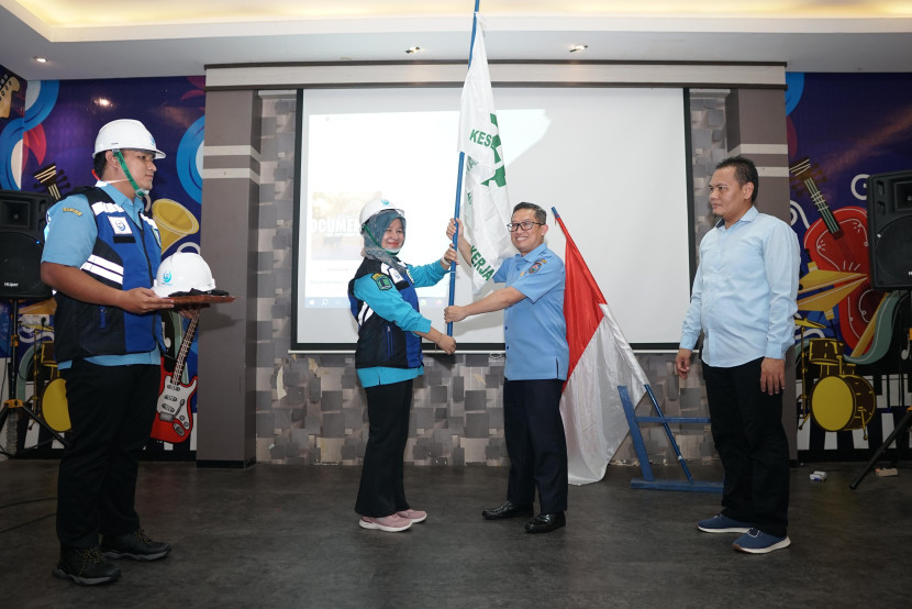 Direktur Utama Perumda Tirta Raja Bertho Darmo Poedjo Asmanto menyerahkan bendera  Keselamatan dan Kesehatan Kerja (K3) kepada karyawan. (FOTO: Dok. Tirta Raja)