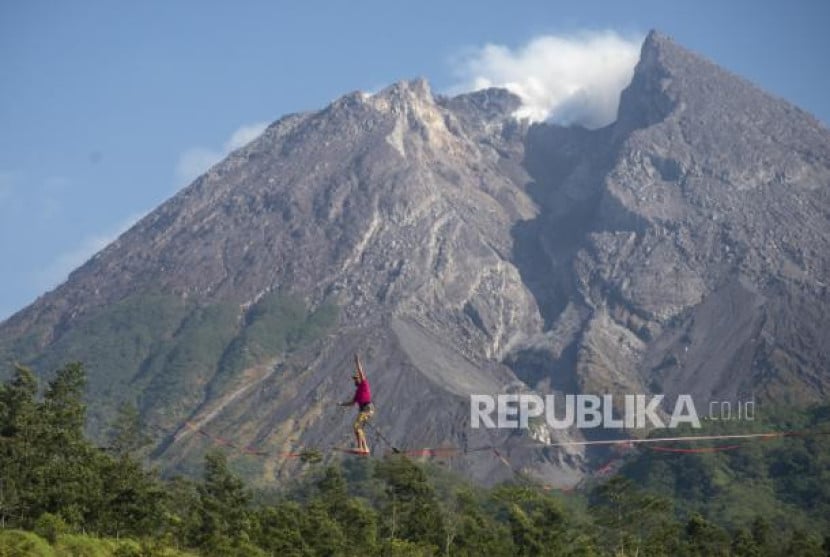 Wisatawan mancanegara berjalan di atas tali saat melakukan olahraga highline di lereng Gunung Merapi, Kalitalang, Balerante, Kemalang, Klaten, Jawa Tengah. (Dok. Republika)