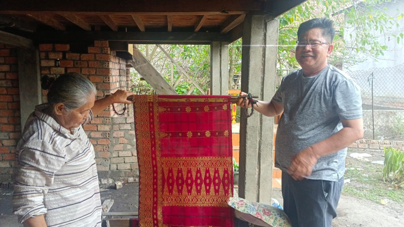 Dedi Irwanto memperlihatkan hasil tenun kain songket yang telah jadi. (FOTO: D Oskandar)