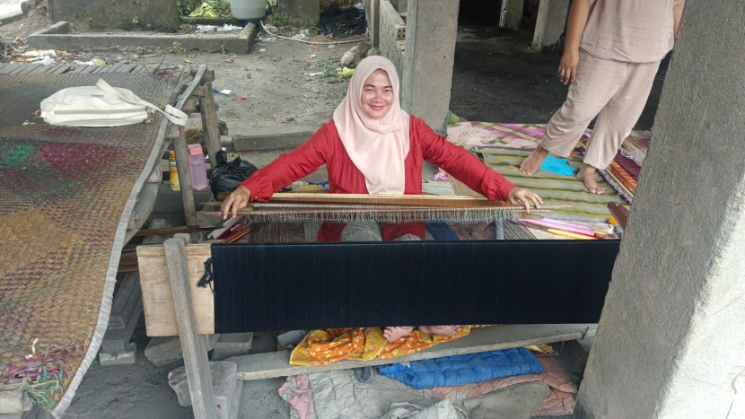 Warga tengah menenun kaon songket menggunakan ATBM setelah mendapat pelatihan dari tim Unsri. (FOTO: D Oskandar)