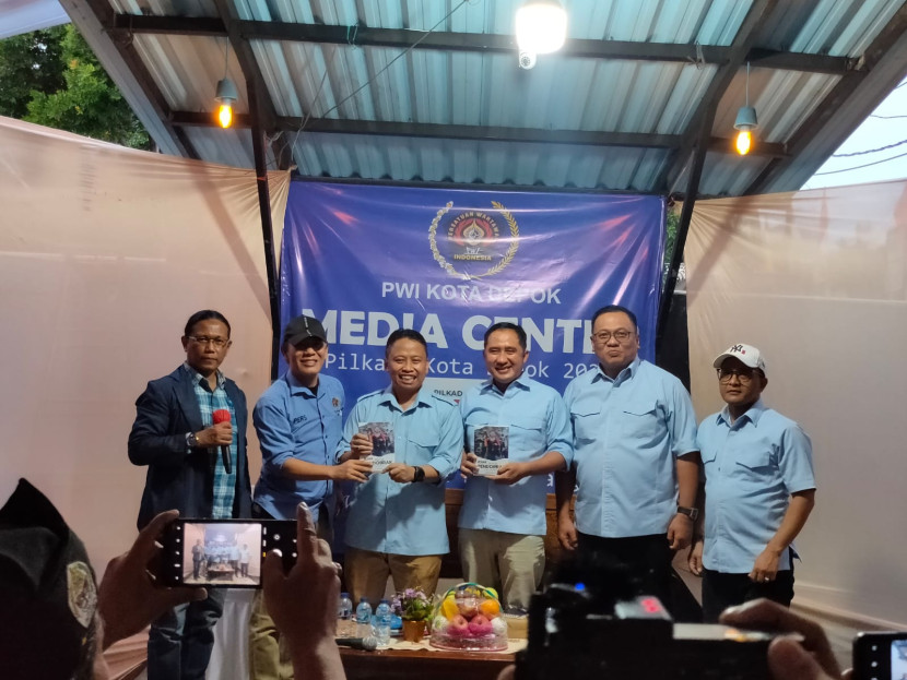 Ketua PWI Kota Depok (kedua kiri) memberikan buku karyanya kepada Calon Wali Kota dan Wakil Wali Kota Depok Supian Suri (ketiga kiri) dan pasangannya Chandra Rahmansyah, didampingi Juru Bicara Pradi Supriatna (kedua kanan).