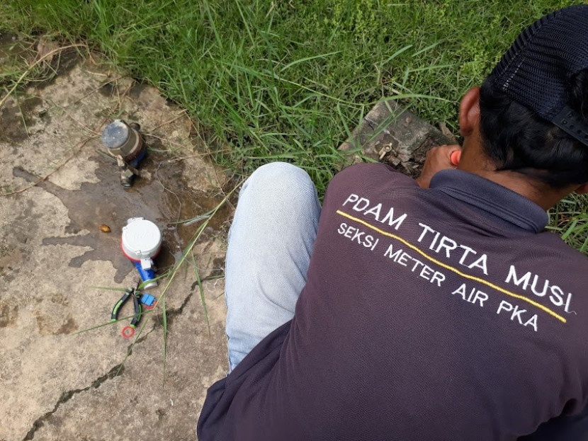 Pekerja PDAM Tirta Musi tengah mengganti meteran air. (FOTO: Maspril Aries)