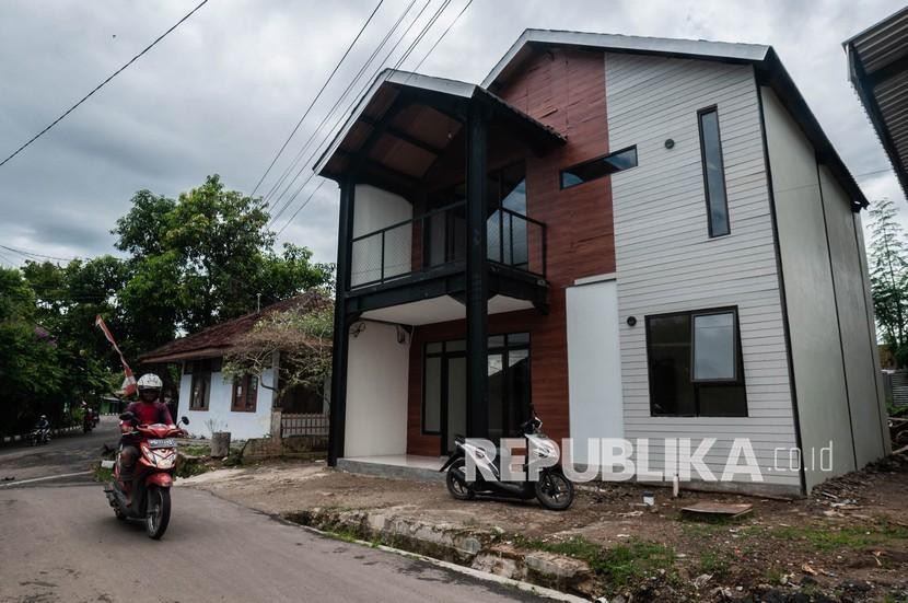 Warga melintas di depan rumah tahan gempa di Rangkasbitung, Lebak, Banten, Jumat (21/1/2022). Foto: Antara/Muhammad Bagus Khoirunas