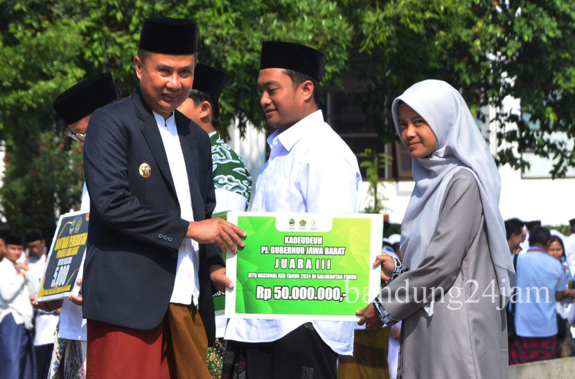 Pj Gubernur Jabar Bey Machmudin memberikan kadeudeuh kepada para santri berprestasi saat peringatan Hari Santri Nasional, di Gedung Sate Bandung, Kota Bandung, Selasa (21/10/2024). Foto: Edi Yusuf