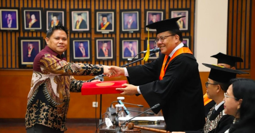 Ferlansius Pangalila, mahasiswa Program Doktor Kriminologi Fakultas Ilmu Sosial dan Ilmu Politik (FISIP) Universitas Indonesia (UI), resmi menyandang gelar doktor setelah berhasil mempertahankan disertasinya berjudul “Viktimisasi Artificial Intelligence di Era Revolusi Industri 4.0” (Foto: Dok Biro Humas & KIP UI)