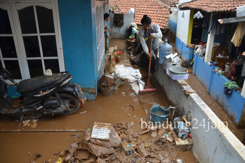 Warga membersihkan rumahnya yang dipenuhi lumpur akibat banjir bandang di Desa Banjaran Wetan, Kecamatan Banjaran, Kabupaten Bandung, Rabu (6/11/2024). Foto: Edi Yusuf