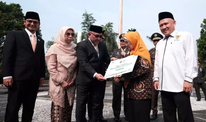 Ketua Baznas Kota Depok, Endang Ahmad Yani (kiri) menyaksikan penyerahan tali asih ke salah satu veteran oleh Wali Kota Depok, Mohammad Idris. (Foto: Dok Diskominfo Kota Depok)