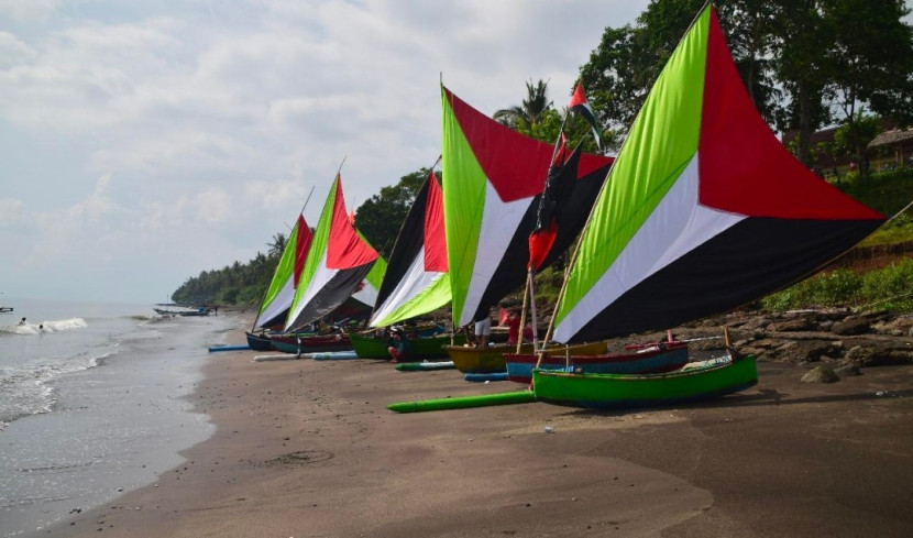 Perahu dengan layar bendera Palestina merapikan acara lomba Omplok Layar di Kawasan Masjid Pantai Bali, Desa Cupel, Kecamatan Negara, Kabupaten Jembrana, Bali. (Foto: Dok panitia lomba Omplok Layar)