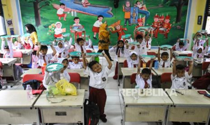 Sejumlah siswa menunjukkan wadah berisi makanan saat uji coba program makan bergizi gratis di SDN Sukasari 5, Kota Tangerang, Banten. Gambar: Republika