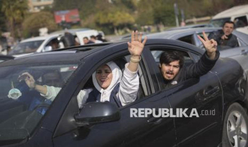 Warga merayakan tumbangnya Dinasti Assad dan jatuhnya ibu kota Damaskus ke tangan pasukan oposisi, di Homs, Suriah, Ahad (8/12/2024). (FOTO : AP Photo/Ghaith Alsayed)