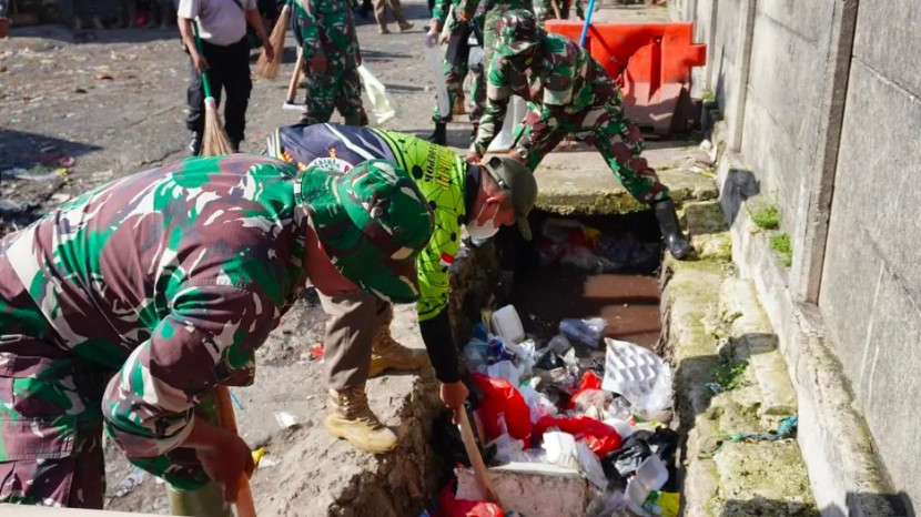 Personel TNI AD dari Kodim Depok bergotong royong membersihkan area Pasar Kemiri, Kota Depok, Jumat (13/12/2024). (Foto: Dok Kodim Depok)