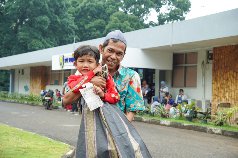 Seorang anak yang telah selesai menjalani khitan digendong oang tuanya. (FOTO: Humas Pusri)