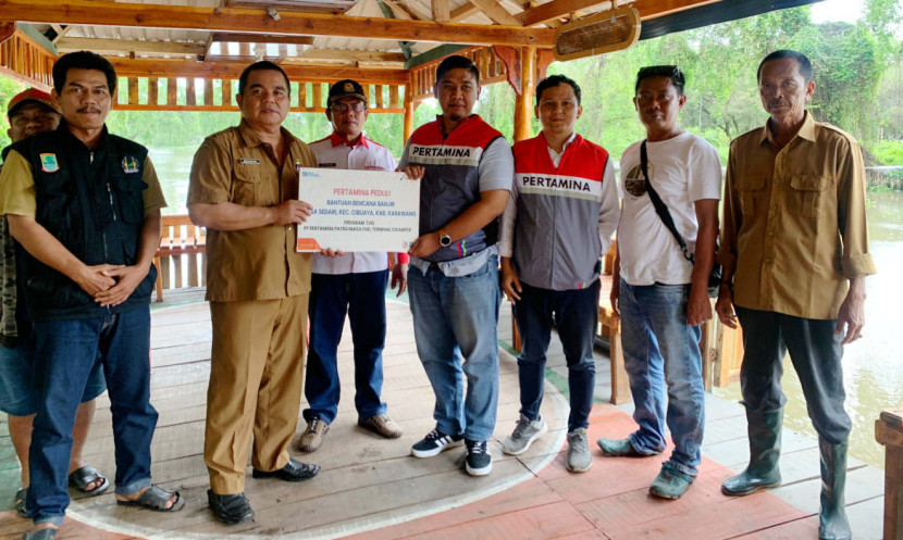 Pertamina Patra Niaga memberikan bantuan 125 paket sembako untuk memenuhi kebutuhan warga terdampak banjir rob dan diterima langsung oleh Kepala Desa Sedari Bisri Mustopa. (Foto: Dok RUZKA INDONESIA)