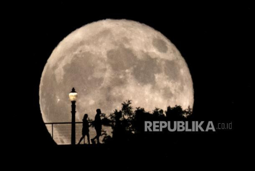 Orang-orang berjalan di depan bulan purnama super (supermoon) di Observatorium Griffith di Los Angeles, Senin, 19 Agustus 2024. Foto: AP Photo/Richard Vogel