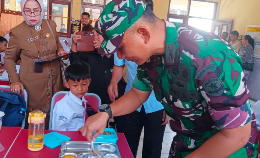 Dandim Depok, Kolonel Iman Widhiarto saat memberikan makan seorang pelajar SDN Cilangkap 5, Tapos, Kota Depok, Senin (06/01/2025). Pemberian makanan Ini merupakan progam makanan bergizi gratis (MBG). (Foto: Dok RUZKA INDONESIA)