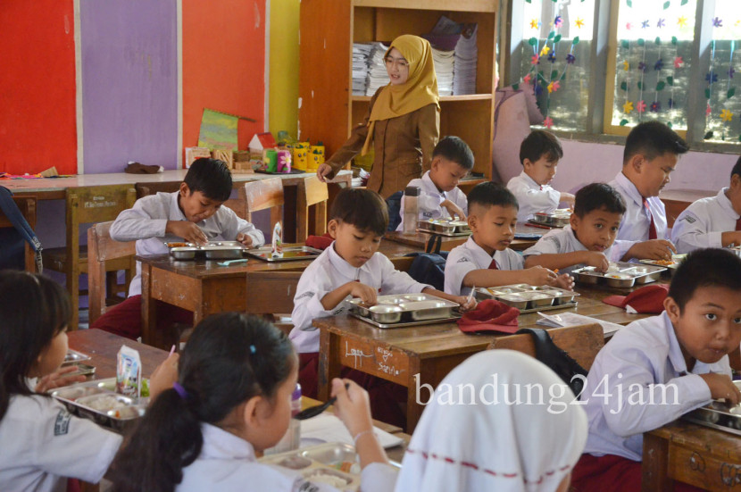 Para pelajar menikmati sajian Makanan Bergizi Gratis (MGB) di SDN 193 Caringin, Sukajadi, Kota Bandung, Senin (6/1/2025). Foto: Edi Yusuf