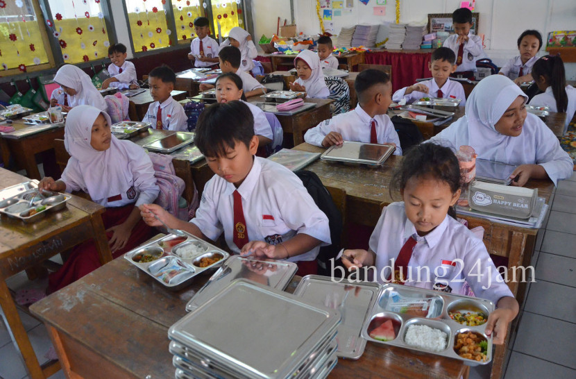 Para pelajar menikmati sajian Makanan Bergizi Gratis (MGB) di SDN 193 Caringin, Sukajadi, Kota Bandung, Senin (6/1/2025). Foto: Edi Yusuf