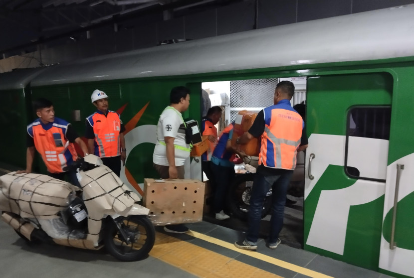 Petugas tengah memasukan paket ke kereta api. Dok istimewa