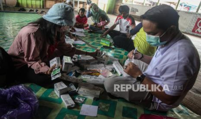 Petugas kesehatan memberi obat dan vitamin. 