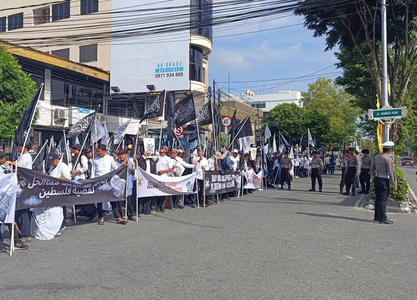 Massa membawa varian spanduk dan bendera hitam serta putih. 