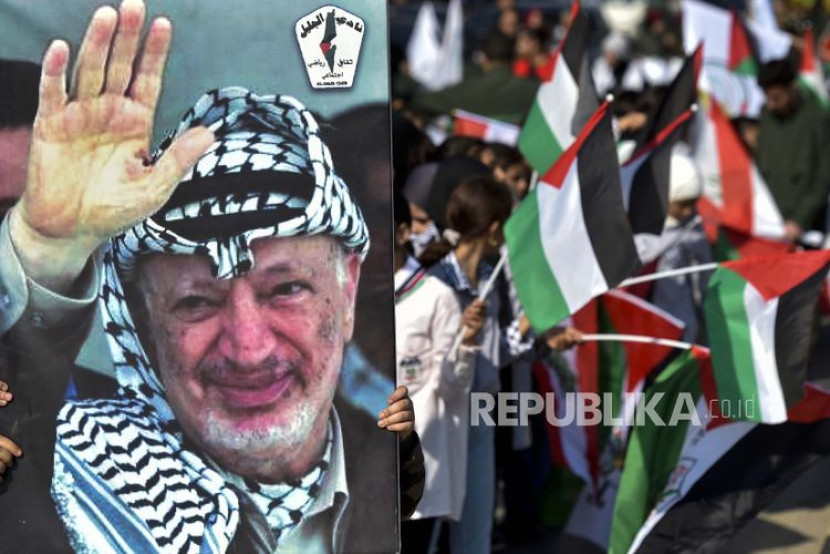 Pendukung Fatah Palestina memegang foto almarhum pemimpin Palestina dan pendiri Fatah Yasser Arafat di Beirut, Lebanon, 11 November 2022. Foto: EPA-EFE/WAEL HAMZEH