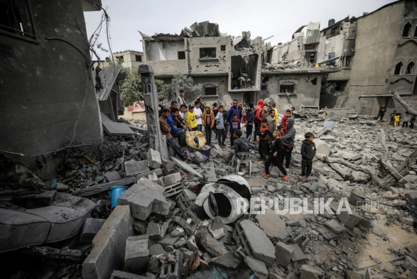 Warga Gaza berkerumun di tengah reruntuhan puing bangunan. 