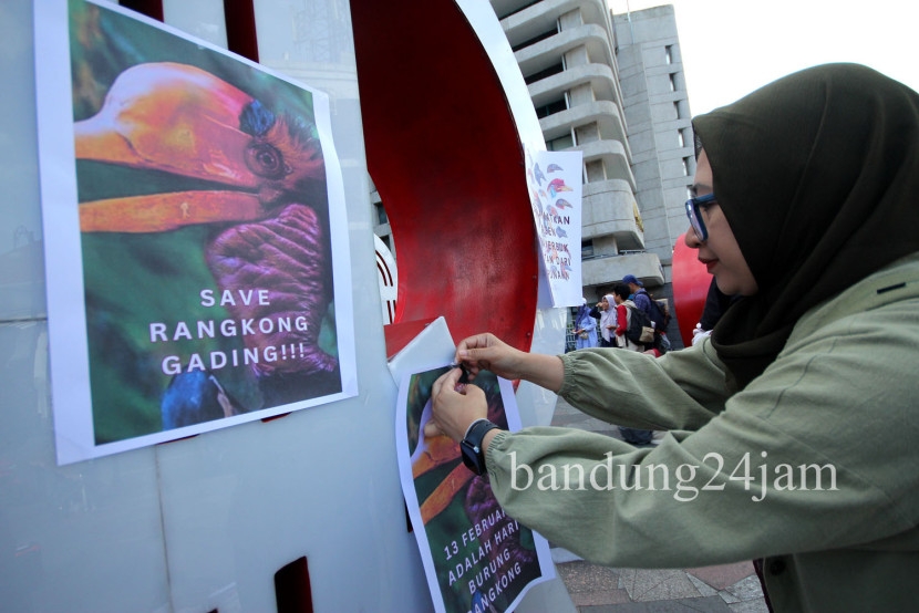  Penulis Foggy FF menempelkan sejumlah poster burung Rangkong saat aksi memperingati Hari Burung Rangkong ‘Love Hornbills Day’ di Taman Braga, Kota Bandung, Kamis (13/2/2025). Foto: Edi Yusuf