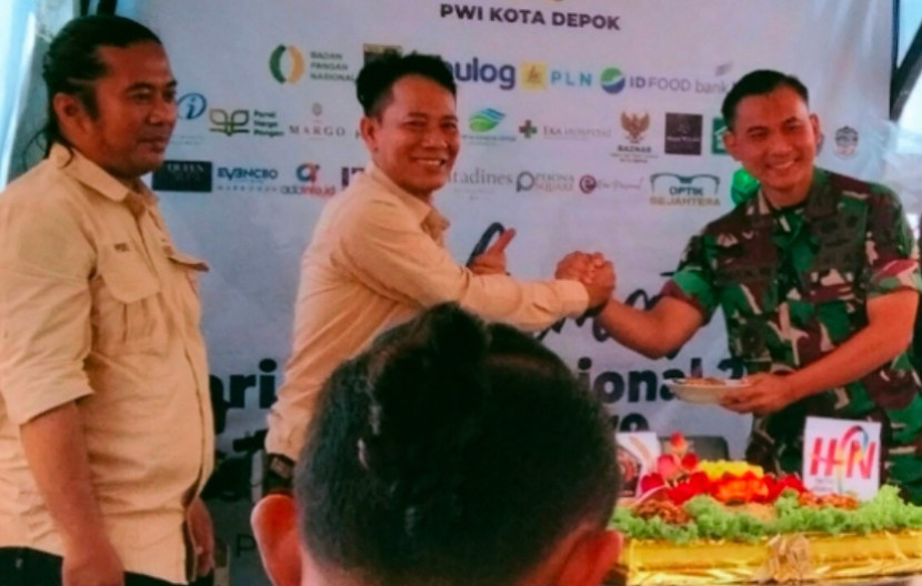 Ketua PWI Kota Depok, Rusdy Nurdiansyah memberikan nasi tumpeng ke Dandim Depok, Kolonel Iman Widhiarto. PWI Kota Depok memberikan piagam penghargaan kepada Dandim atas Partisipatif Program Ketahanan Pangan. (Foto: Dok RUZKA INDONESIA)