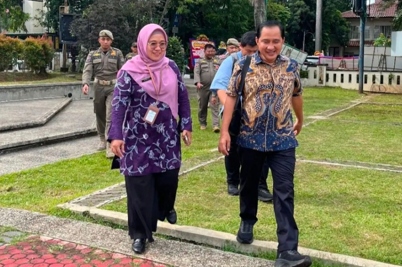 Wakil Wali Kota Depok, Chandra Rahmansyah (kiri) dihari kerja pertama, berjalan kaki dari rumahnya di  Pesona Depok Estate ke Balai Kota Depok. Setibanya di Balai Kota Depok disambut Kasie Protokol Pemkot Depok, Startika. (Foto: Dok Diskominfo Kota Depok)