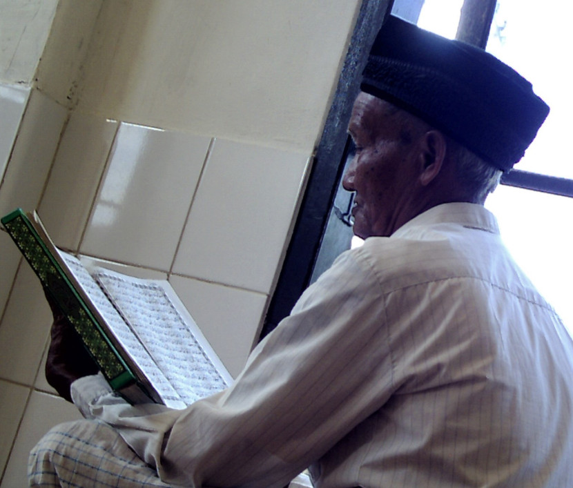 Usia tidak menghalangi seorang kakek untuk membaca Al-Quran. (Foto: SumatraLink.id/Mursalin Yasland)