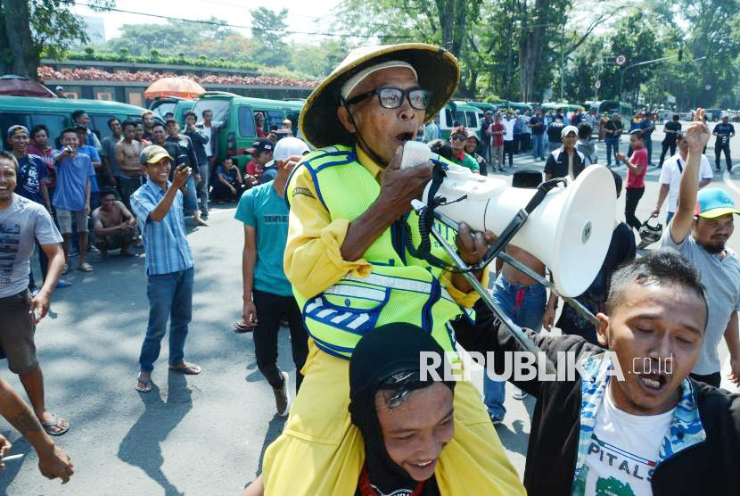 Sariban mengingatkan peserta aksi supir angkot agar menjaga kebersihan. Foto: Edi Yusuf 