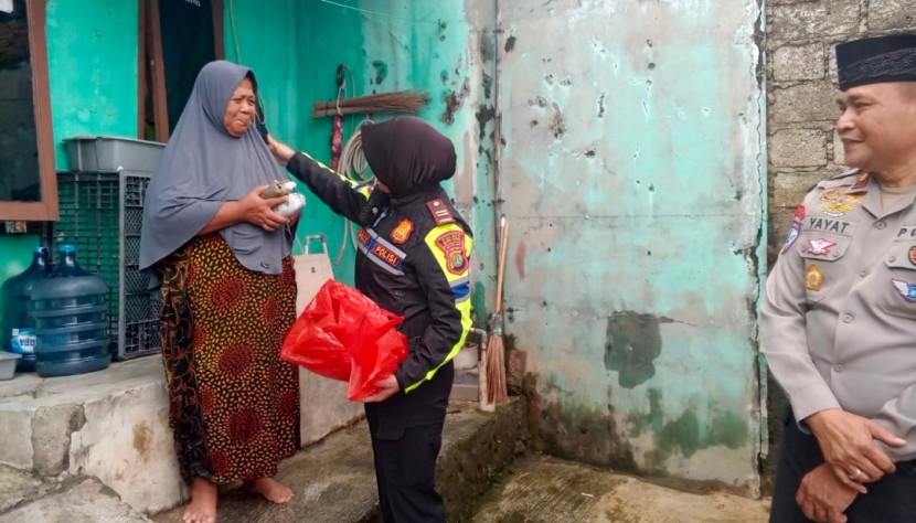 Kanit Kamsel Sarlantas Polrestro Depok, AKP Elly Pandiansari sedang membagikan makanan ke warga korban banjir di Perum Sawangan Permai, Selasa (04/03/2024). (Foto: Dok RUZKA INDONESIA) 