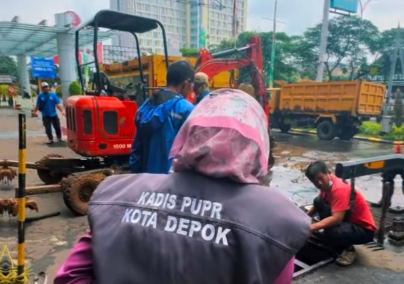 Kepala Dinas PUPR Kota Depok, Citra Indah Yulianty menyaksikan alat berat mini spider mengangkat sampah dari bak kontrol Kali Cabang Timur yang berada dibawah jalan area mal Detos. (Foto: Dok RUZKA INDONESIA) 