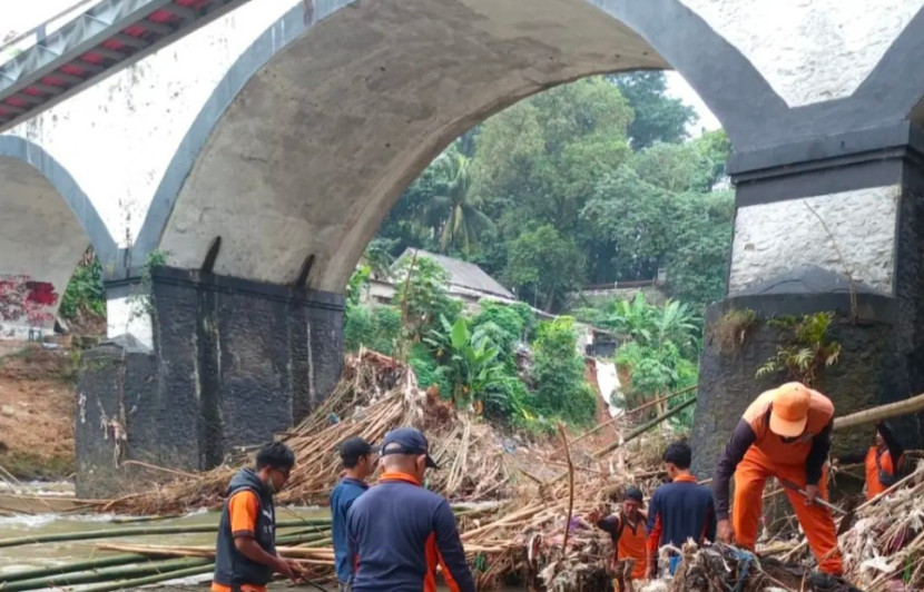 DLHK Kota Depok bersihkan sampah yang tersangkut di Jembatan Panus. Sampah yang menumpuk menghambat aliran Sungai Ciliwung yang melintas Kota Depok. (Foto: Dok Diskominfo Kota Depok) 