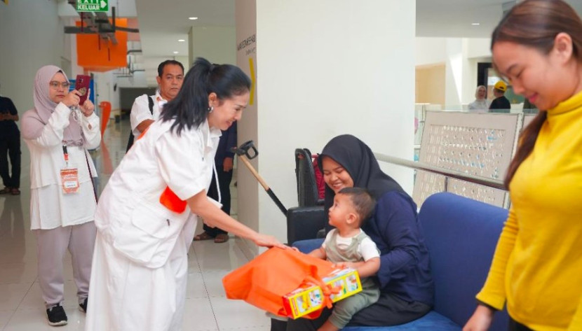 Seorang anak seusai operasi bibir sumbing dI RSUI mendoakan bingkisan. (Foto: Dok Humas RSUI) 