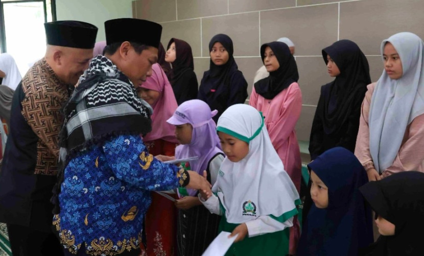 Direktur RSUD KiSA Depok, Sobari saat menyerahkan satunan kepda anak yatim. (Foto: Dok Diskominfo Kota Depok)