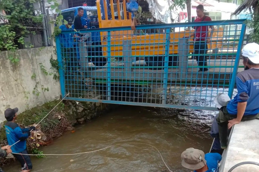 Satgas Dinas PUPR Kota Depok memasang jaring sampah di Kali Cabang Barat (KCB) di Kelurahan Mampang, Kecamatan Pancoran Mas, Kota Depok, Jumat (21/03/2025). (Foto: Dok Diskominfo Kota Depok) 