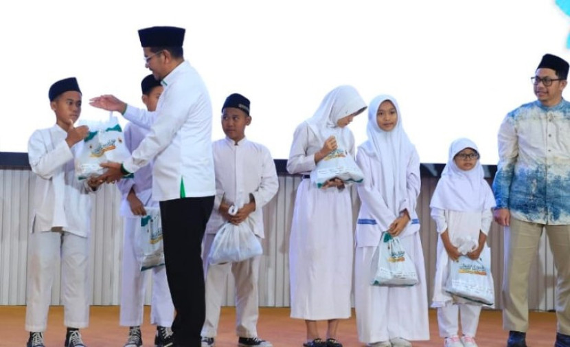 Direktur Jenderal Bimas Islam, Abu Rokhmad secara serimoni membagikan bingkisan ke anak-anak yatim piatu. (Foto: Dok Kemenag) 