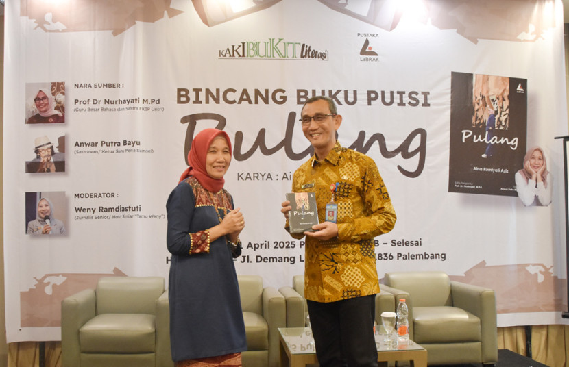 Penulis perempuan Aina Rumiyati Aziz menyerahkan buku puisi