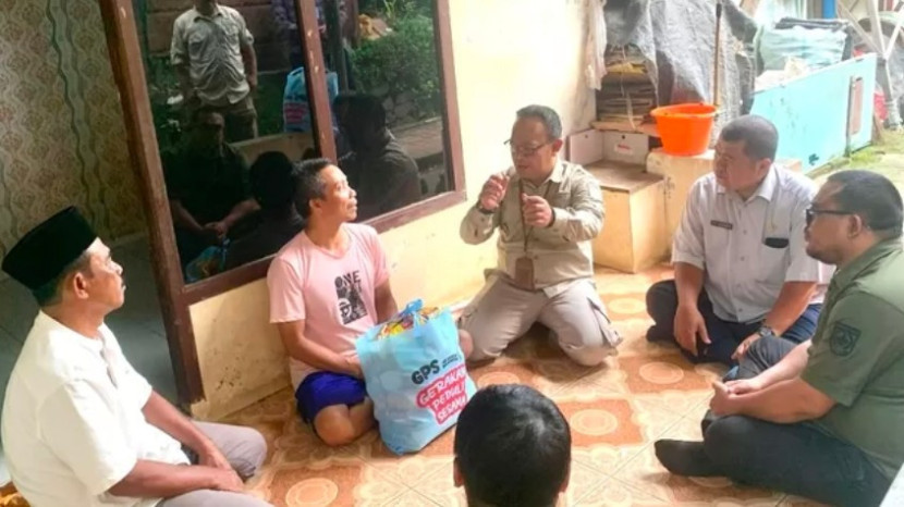 Camat Bojongsari, Rijal Farhan saat memberikan bantuan ke warga yang mengalami kebutaan akibat kecelakaan. (Foto: Dok Diskominfo Kota Depok) 