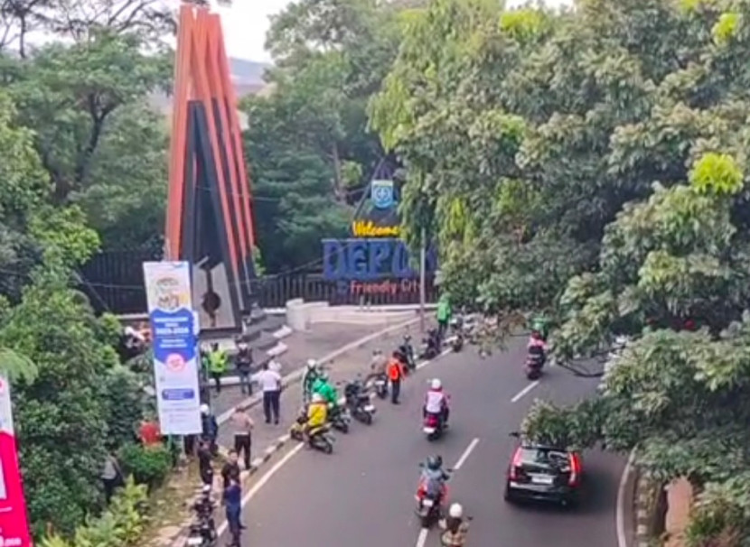 Pengendara kendaraan berhenti melihat ada sosok mayat yang diduga bunuh diri di Tugu Selamat Datang Kota Depok, Kamis (08/05/2025). (Foto: Dok RUZKA INDONESIA)